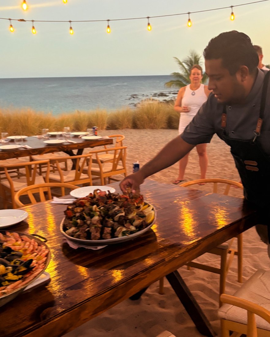 A beach dinner in Los Cabos at dusk, lit by string lights